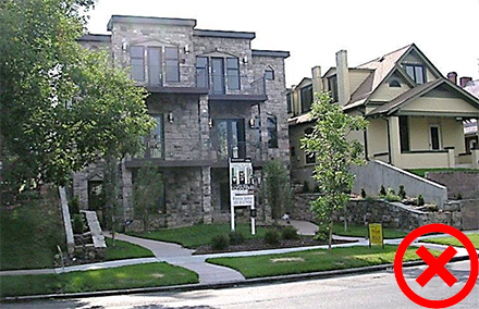 An incorrect example of grading that shows the difference between the yellow house on the right's gradual slope compared to the newer brown house with no slope